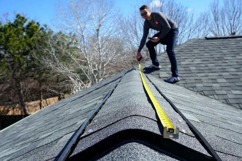 grand rapids man measuring the roof